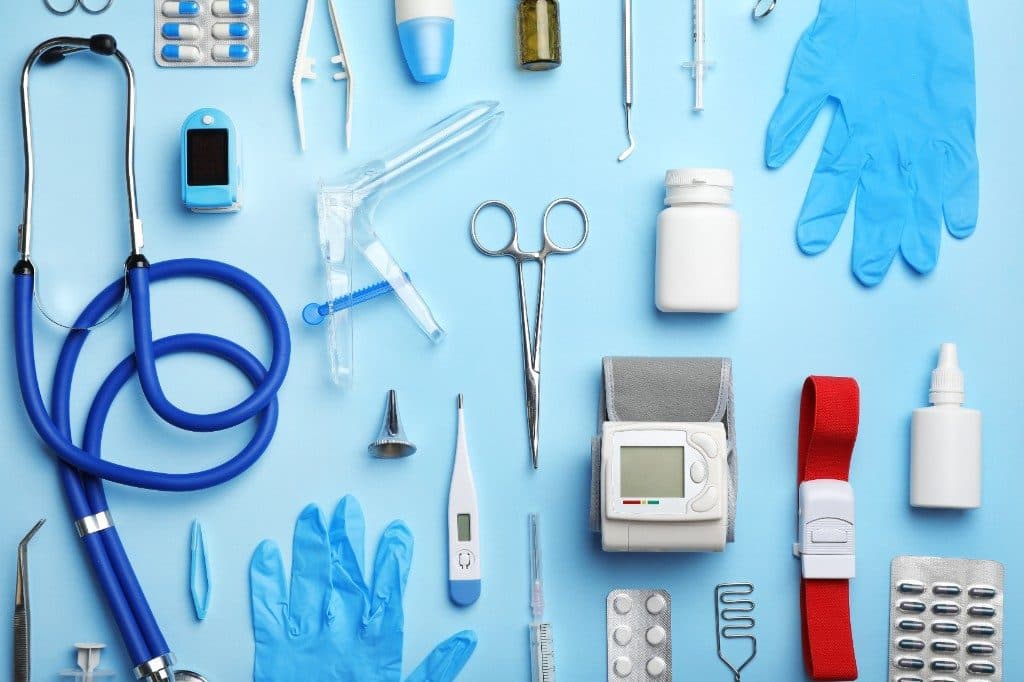 Matériel médical professionnel disposé sur fond bleu — stéthoscope, instruments et équipements